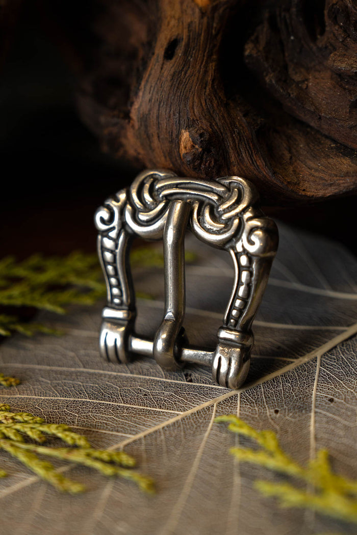 Viking buckle gripping hands, silvered