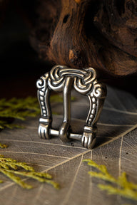 Viking buckle gripping hands, silvered