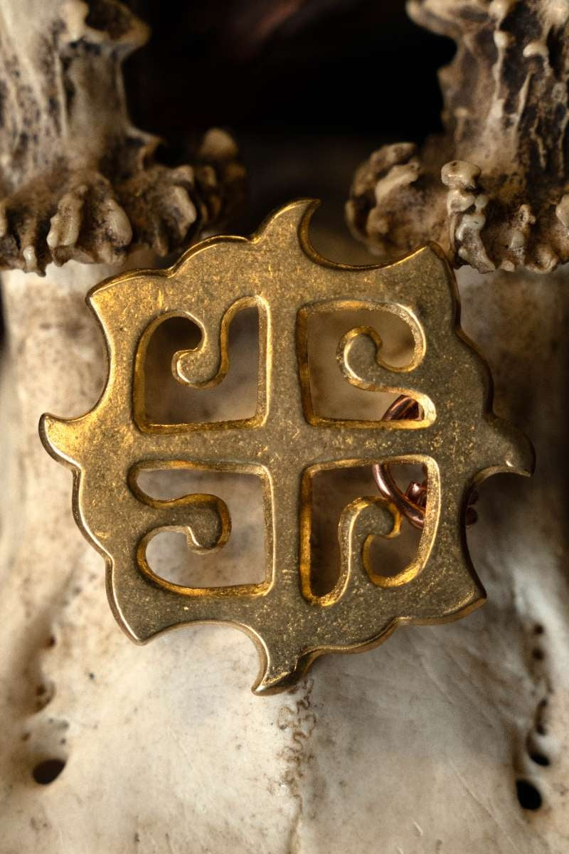 Fibula romana a disco con croce solare, bronzo