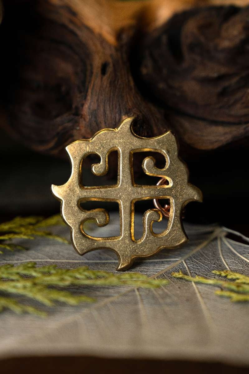 Fibula romana a disco con croce solare, bronzo